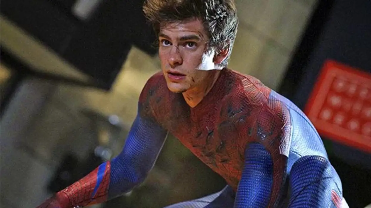 Grainy photograph of Andrew Garfield playing Spider-man, wearing the blue-and-red suit except for the mask. His face is a bit scraped up.
